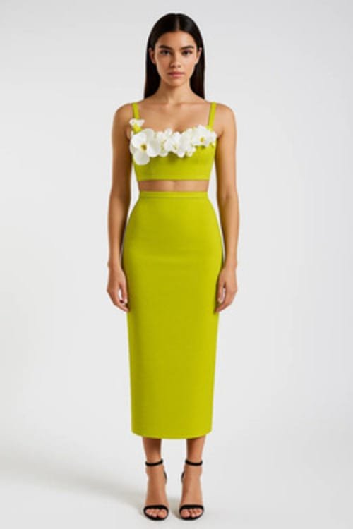 A model in a bright green bandage dress with floral embellishments
